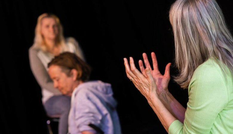 Theaterstück mit drei Frauen eine Frau hält die Hände nach oben